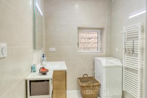 a white bathroom with a sink and a toilet at Maisonnette d'Artiste au cœur des ruelles médiévales in Trévoux +21 photos