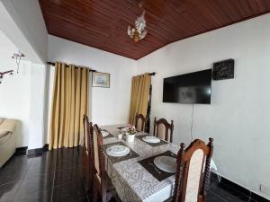 a dining room with a table and a television at Vintage Voyage Villa in Negombo