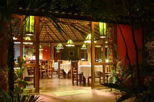 a restaurant with tables and chairs in a room at Araticum Praia Hotel in Santo André