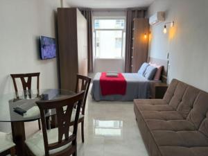 a living room with a couch and a bed at Flat Centro Rio Av Presidente Vargas x Uruguaiana - Vista panorâmica do Cristo & Metrô in Rio de Janeiro