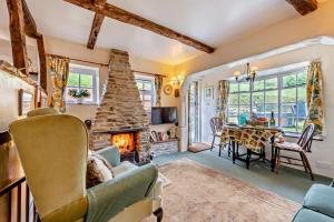 DuloeBramble Cottage - Duloe的带壁炉的客厅和用餐室