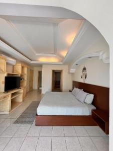 a bedroom with a large bed and a tv at Casa Bonampak 1 in Cancún