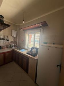 a kitchen with a sink and a refrigerator and a window at Appartement Confortable à Martil in Martil +3 photos