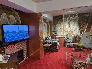 a living room with a tv and a fireplace at LEGENDS Chambers by Grand Pier Boutique in Bucharest