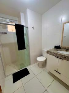 a bathroom with a shower and a toilet and a sink at Apt 2 quartos com Vista Mar Piscina e Varanda 200 m da Praia Ilheus BA in Ilhéus +7 photos