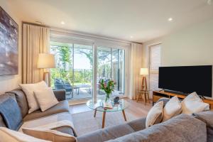 Una sala de estar con un sofá y un televisor. en Harbour Reach - Padstow, en Padstow
