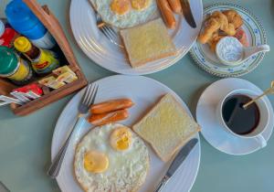ein Tisch mit Tellern mit Frühstücksspeisen und einer Tasse Kaffee in der Unterkunft Sleep สลีพพ in Ban Bung Sam Phan Nok