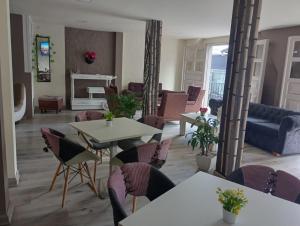 a living room with tables and chairs and a couch at Hotel Las Flores in Santa Rosa de Cabal