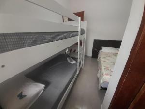 a bedroom with two bunk beds and a bed at Flat novo 103 a pé da Prainha Mambucaba Paraty RJ in Paraty