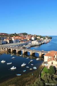a group of boats in a harbor with a bridge at Tercero Loft Susana in San Vicente de la Barquera
