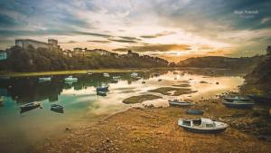 a group of boats in a river at sunset at Tercero Loft Susana in San Vicente de la Barquera