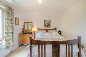 a bedroom with a bed and a dresser and a window at Tump Cottage in Walford