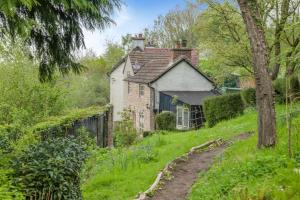 an old house on a hill with a dirt road in front at Tump Cottage in Walford