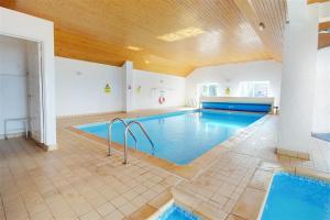 a large swimming pool with blue water in a room at 2 Bed in Putsborough oc-flat31 in Croyde