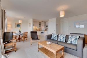 una sala de estar con un sofá y una mesa en Flat 31 Clifton Court, en Croyde