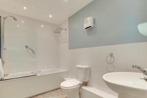 Un baño blanco con inodoro y lavabo. en Flat 31 Clifton Court, en Croyde 9 fotos más