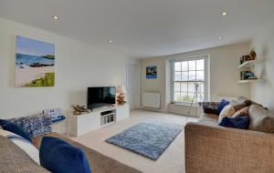 a living room with a couch and a tv at Lobsters Loft in Appledore