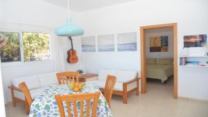 un soggiorno con tavolo, sedie e chitarra di Casa Blanca - Sunset Villa a Valle Gran Rey