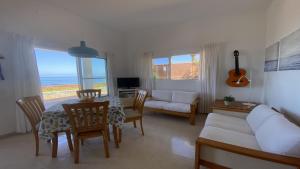 un soggiorno con tavolo, sedie e divano di Casa Blanca - Sunset Villa a Valle Gran Rey