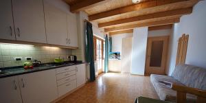 een keuken met witte kasten en een bank in een kamer bij Wirthof in La Valle