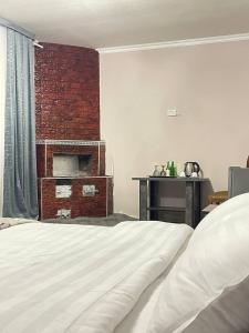 a bedroom with a brick wall and a bed at Kifoyat Hotel in Samarkand