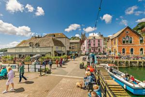 eine Gruppe von Menschen, die auf einem Pier neben einem Fluss spazieren gehen in der Unterkunft Killas Cottage in Fowey