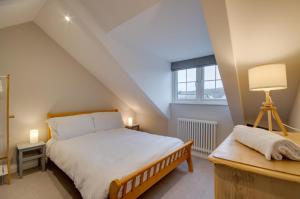 ein Schlafzimmer mit Bett, Schreibtisch und Fenster in der Unterkunft Killas Cottage in Fowey