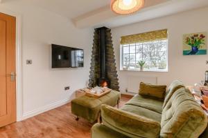 a living room with a couch and a tv at Landscape Cottage in Hinderwell