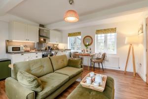 a living room with a couch and a kitchen at Landscape Cottage in Hinderwell