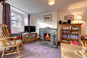 a living room with a fireplace and a chair at Rose Cottage in Chapel Stile