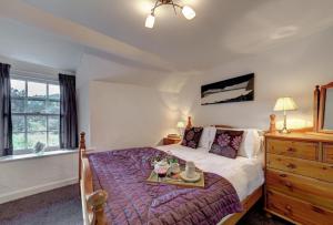 a bedroom with a bed with a tray on it at Rose Cottage in Chapel Stile
