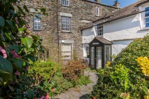 an old stone house with a garden in front of it at Rose Cottage in Chapel Stile