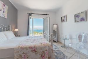 Un dormitorio con una cama y vista al mar. en Villa Mylos, en Kassiopi 39 fotos más