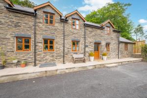 a stone house with a bench in front of it at Hafod y Llwynog in Cross Inn
