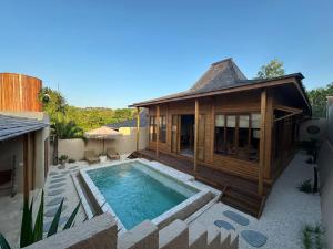 una casa con piscina al lado de un edificio en Villa Summer - Seasons, en Uluwatu