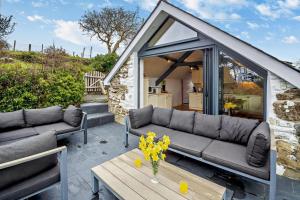 un soggiorno con divano e fiori sul tavolo di Tyn Y Mur Cottage a Llangian