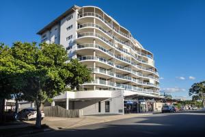 a large white apartment building on the side of a street at Pandanus Mooloolaba in Mooloolaba
