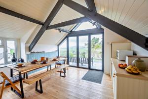 una cucina con un tavolo di legno in una stanza di Tyn Y Mur Cottage a Llangian
