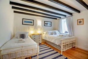 una camera da letto con due letti e una finestra di Tyn Y Mur Cottage a Llangian