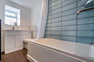 un bagno bianco con vasca e WC di Tyn Y Mur Cottage a Llangian Altre 18 foto
