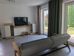 a living room with a couch and a tv at Ferienwohnung Familie Baus in Hammelburg