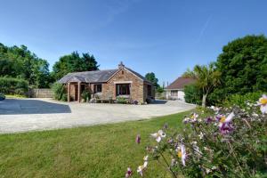 a stone house with a yard with flowers at Gwels Efan Barn in Saint Issey