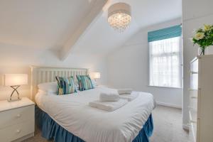 a bedroom with a large white bed with blue pillows at West Pier Flats in St Ives