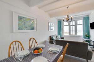 a dining room and living room with a table and chairs at West Pier Flats in St Ives +6 photos