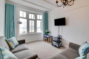 a living room with a couch and a tv at West Pier Flats in St Ives