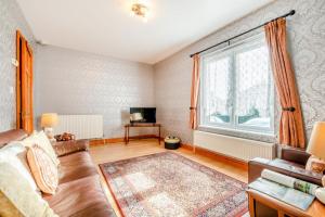 Una sala de estar con un sofá y una ventana grande. en Tremill Lodge, en Wadebridge