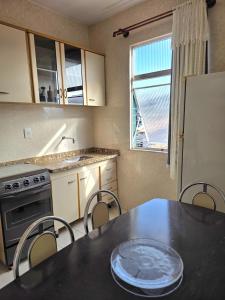 eine Küche mit Tisch und Stühlen und einem Kühlschrank in der Unterkunft Apto no coração da Praia do Forte em Cabo Frio in Cabo Frio