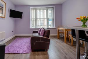 a living room with a couch and a piano at White Rose 1 in Tenby