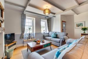 una sala de estar con un sofá y una mesa en Bay Cottage, en Gorran Haven