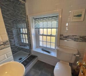 Un baño con inodoro, lavabo y ventana. en Bay Cottage, en Gorran Haven 20 fotos más